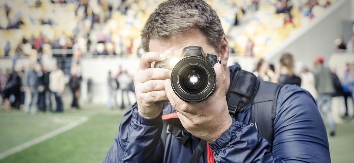 Man with a camera, taking a picture.